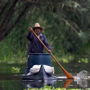 man paddles down a river
