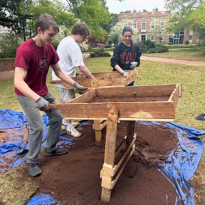 students sift dirt at archaeological dig